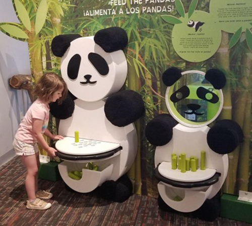 2 wooden panda bears with peg tables. Little girl placing peg in one hole on table as it sticks up.
