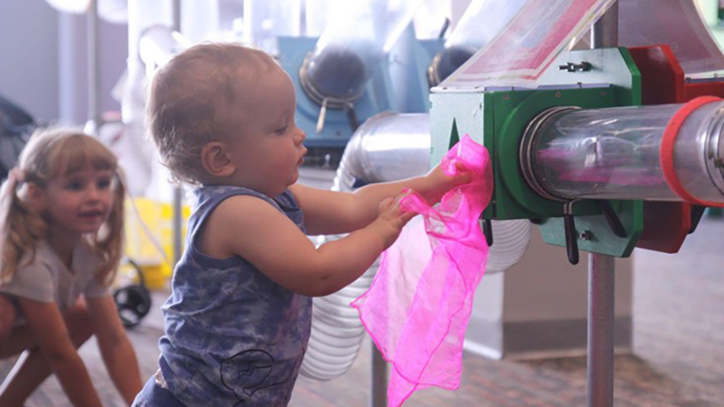 KidsPlay Birthday - Little girl holding see through cloth and pushing it onto the air tubes.