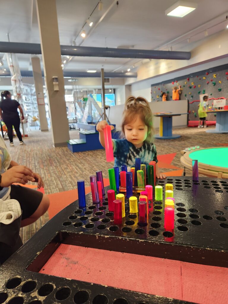 A photo of a young child playing with an exhibit.