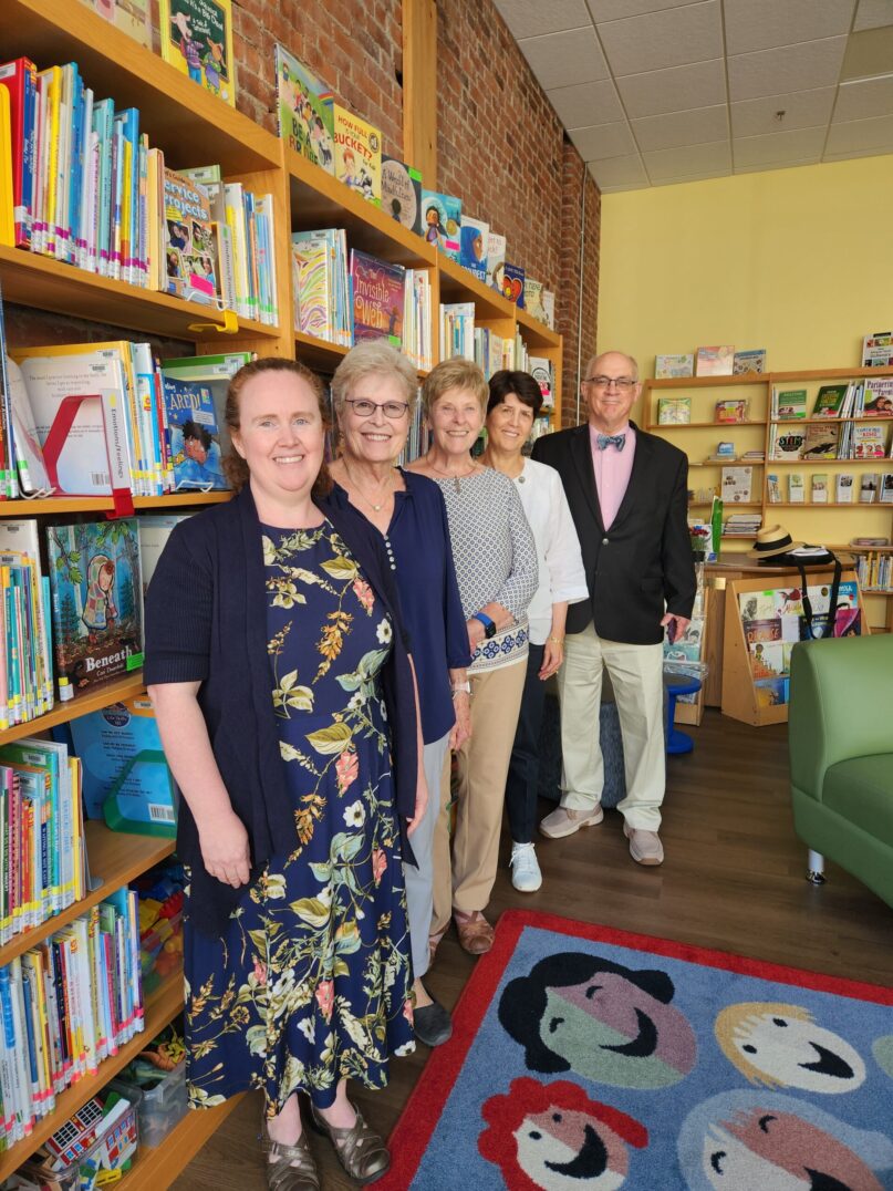 Museum Assessment Program: A photo of five people (Eileen Marriott, Cathy Schmitz, Mary Guilfoile, Cheryl Kloczko, and Mac Sudduth) standing in front of a bookshelf in KidsPlay's CFLC Library. These people helped KidsPlay participate in the Museum Assessment Program.