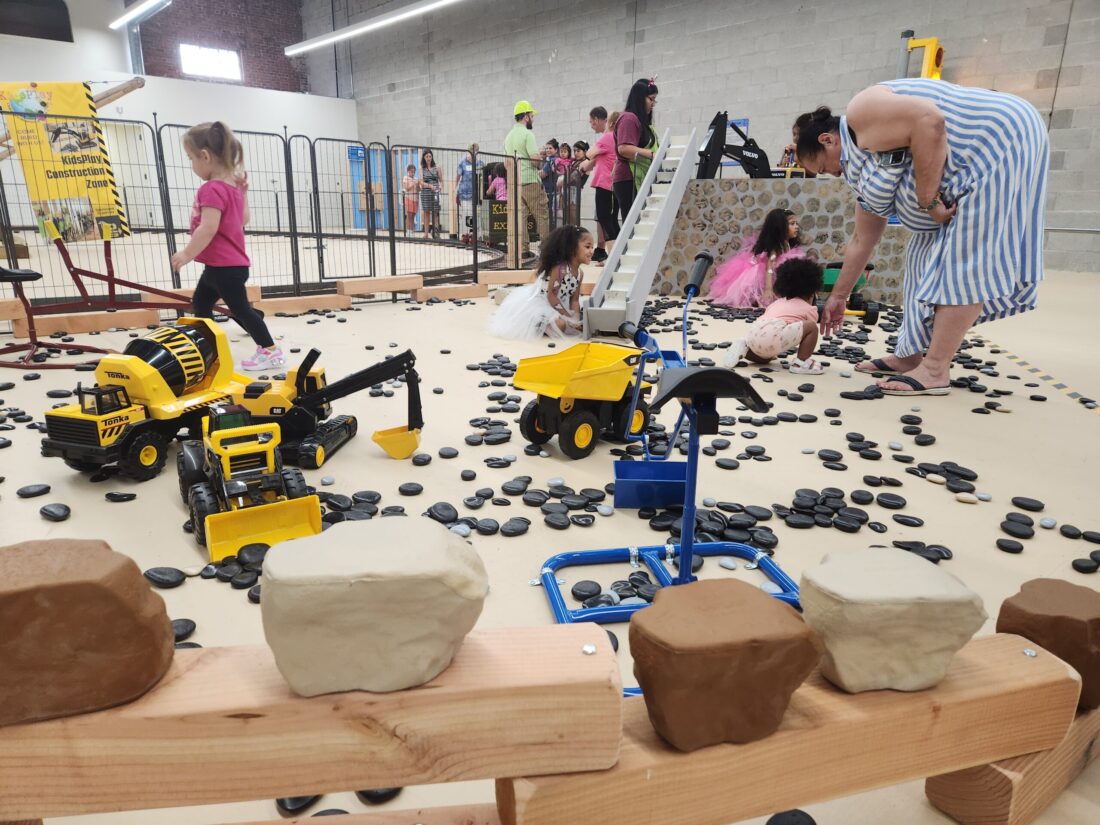 A photo of children and adults playing in KidsPlay's new Construction Exhibit.