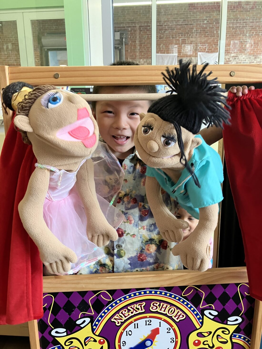 A photo of a young boy playing with puppets in the CFLC Library at KidsPlay Children's Museum in Torrington, Connecticut.