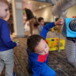 Two children playing with the Air Tubes exhibits at KidsPlay.