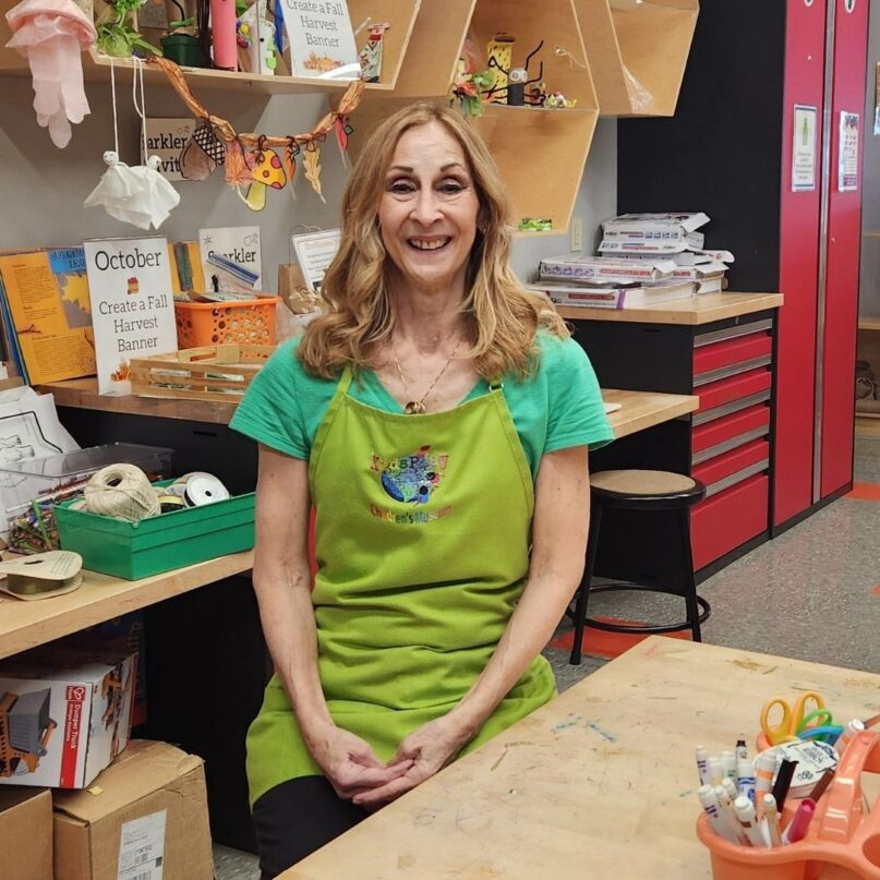 A photo of Deb Kellogg, Senior Guest Service Associate at KidsPlay Children's Museum in Torrington, CT sitting in the KidsPlay Maker Space.